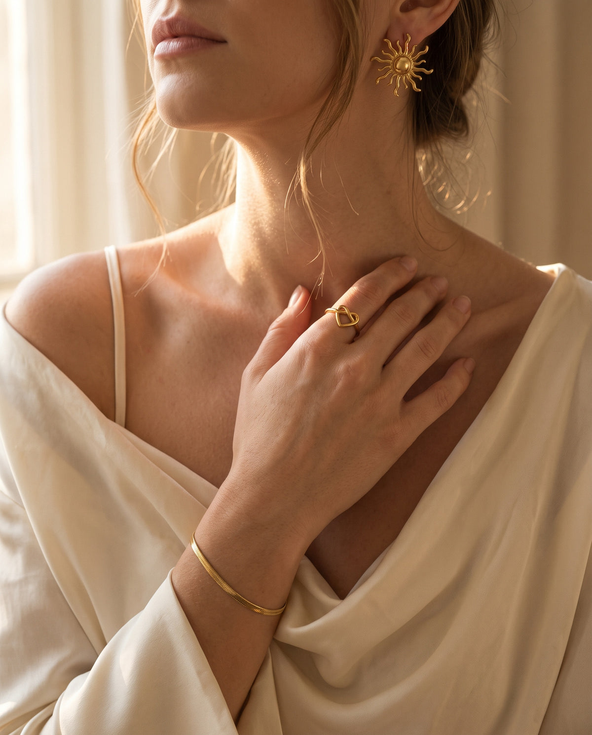 Gold heart ring, sun earrings and fine chain bracelet worn together