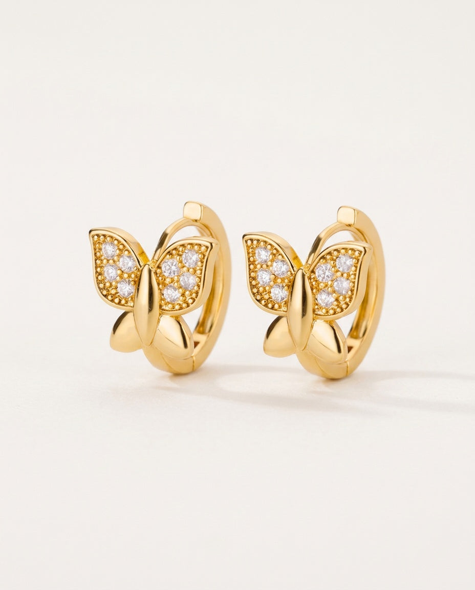 Gold butterfly earrings on small hoops with tiny clear stones
