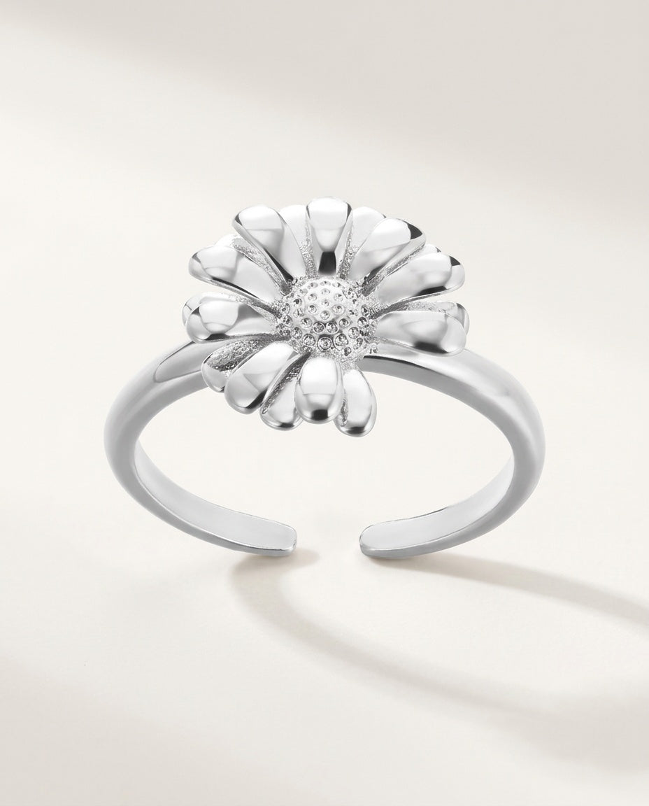 Gold daisy flower ring on an open adjustable band, on white