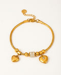 Heart bracelet in gold with heart charms and zircon details on a white background